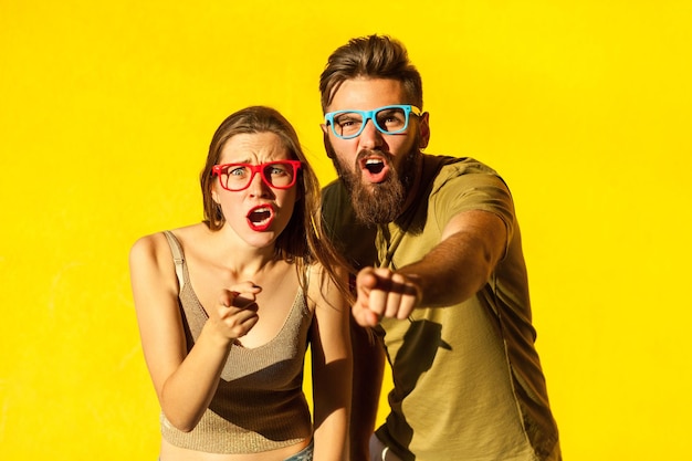 Shocked couple pointing at camera