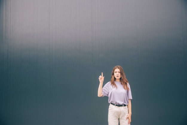 Shocked emotional woman pointing up in air