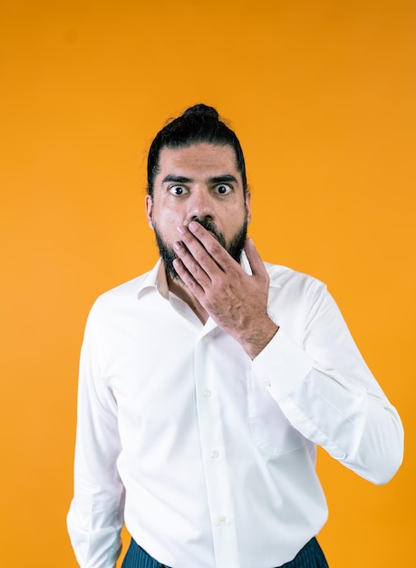 Shocked ethnic businessman covering mouth