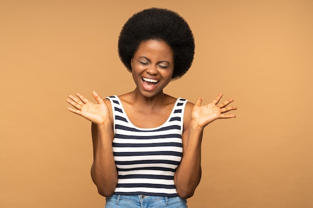 Shocked or excited african girl screaming with closed eyes and open palms scared female shouting