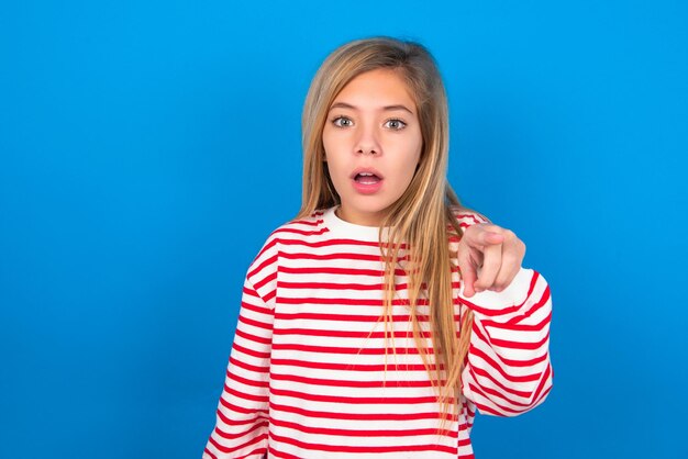 Shocked girl points front with index finger at camera and surprise and advertisement concept