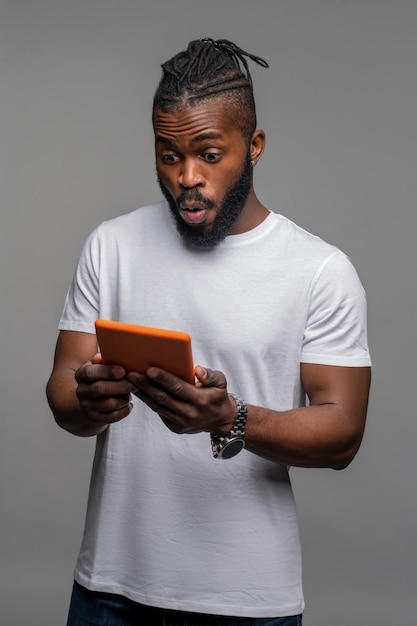 Shocked guy staring at the gadget in his hands