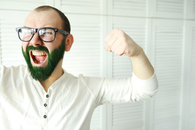 Shocked and happy. happy saint patricks day. bearded man with\
wide open eyes celebrating saint patricks day. hipster in\
leprechaun hat and costume. irish man with beard wearing\
green.