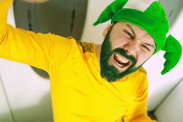 Shocked and happy happy saint patricks day bearded man with
wide open eyes celebrating saint patricks day hipster in leprechaun
hat and costume irish man with beard wearing green