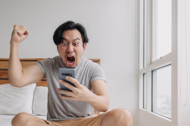 Shocked and happy man get good news from the smartphone