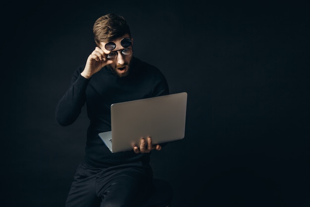 Shocked man in glasses looking at laptop