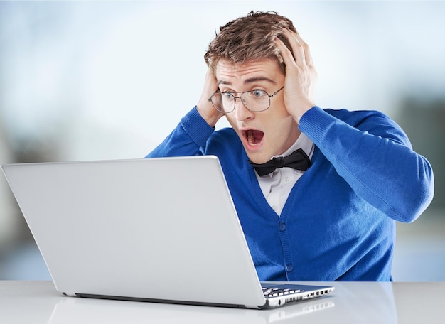 Shocked man in  glasses with laptop