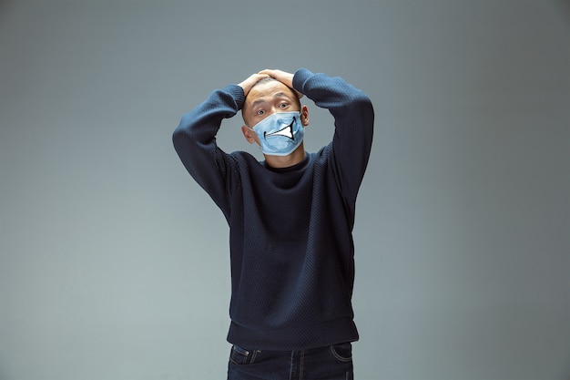 Photo shocked. portrait of young man with emotion on his protective face mask