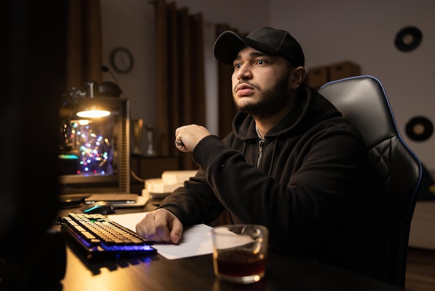 Shocked puzzled programmer it specialist hacker internet criminal in black sweatshirt