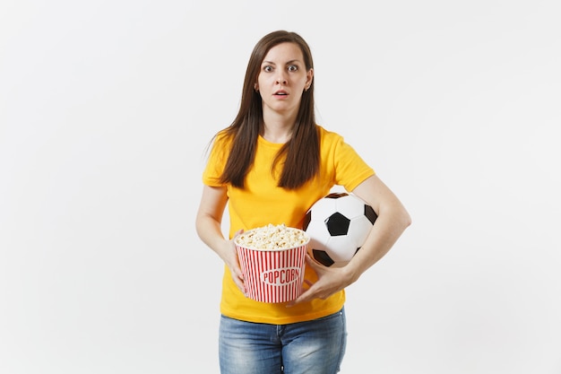 Shocked sad european woman, football fan holding soccer ball,\
bucket of popcorn upset of loss or goal of favorite team isolated\
on white background. sport, play football, cheer, fans lifestyle\
concept