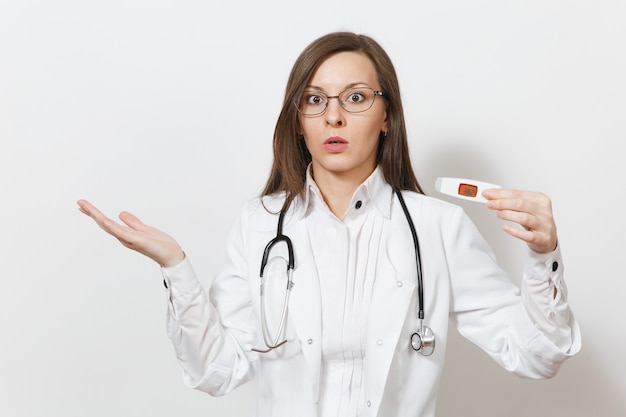 Shocked sad upset young doctor woman in medical gown with stethoscope, glasses, clinical electronic thermometer with high fever temperature isolated on white background. Healthcare personnel concept.