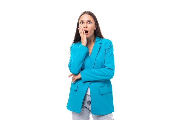 Shocked stylish young brunette businesswoman in blue jacket on white background with copy space