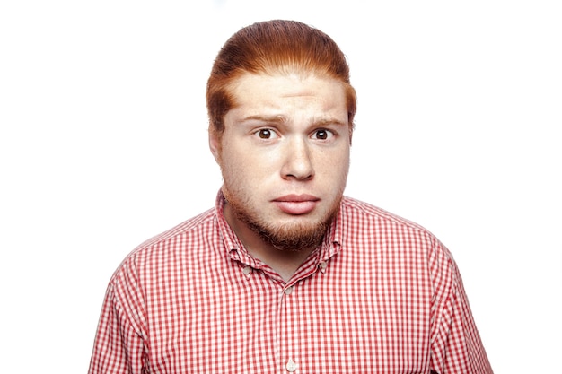 Photo shocked surprised bearded readhead businessman with red shirt and freckles looking at camera