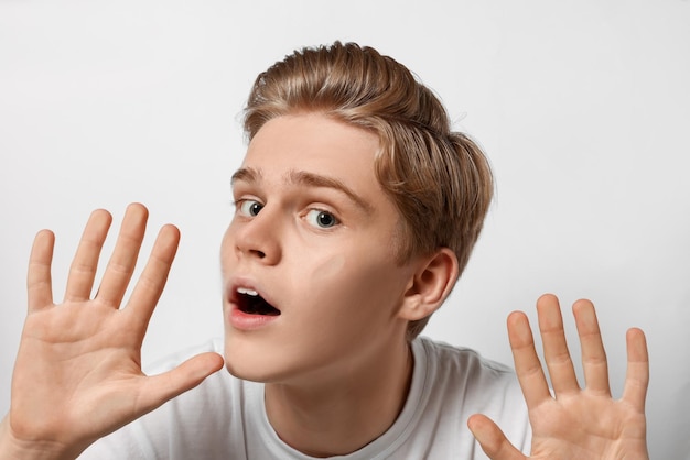 Shocked teenage boy stuck to transparent screen