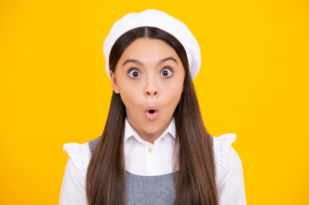 Shocked teenager child portrait isolated on yellow background Surprised teenage girl