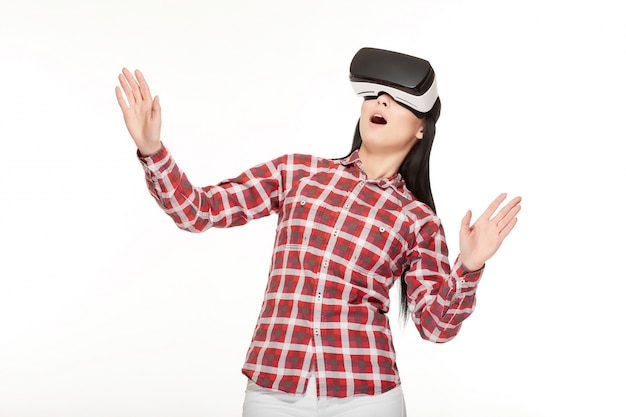 Photo shocked woman playing game in virtual reality and gesturing.