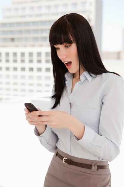 Shocked woman reads a text off of her phone