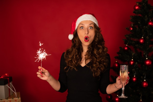 Shocked woman in Santa Claus hat celebrates Christmas