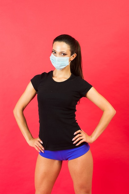 Shocked young fitness woman in sportswear sterile face mask working out isolated on yellow background studio portrait. 
