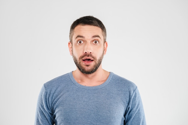 Shocked young man standing isolated