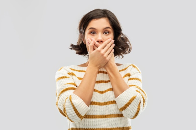 shocked young woman covering her mouth by hands