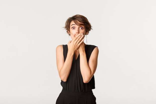 Photo shocked young woman found out secret, gasping and shut mouth with hands amazed
