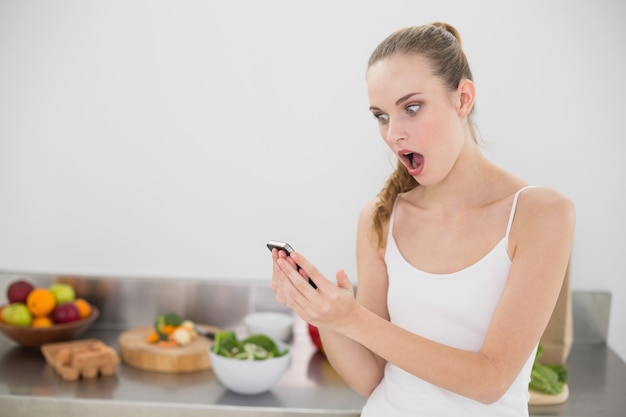 Shocked young woman reading a texting