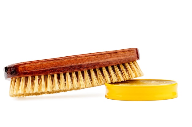 Shoe brush and shoe cream jar are isolated on a white background.