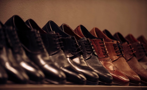 Shoe collection of black and brown leather on shelf. Mens shoes on display in shop. Footwear fashion and style. Shopping on black Friday and sale