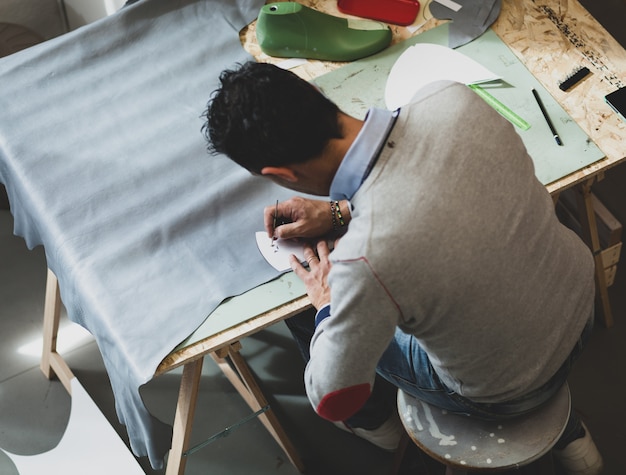 Shoe designer working with leather.