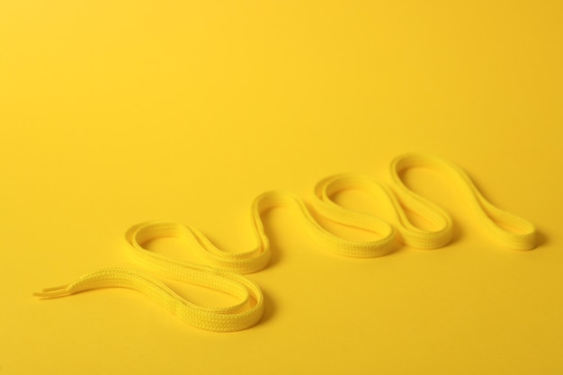 Shoe lace on yellow background Space for text