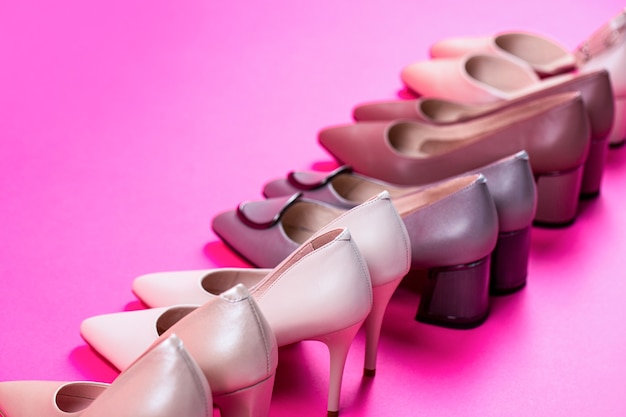 Обувь женская. Стильная классическая женская кожаная обувь. Женские туфли на высоком каблуке на красном фоне. Понятие красоты и моды. Модная женская обувь, изолированные на розовом фоне.