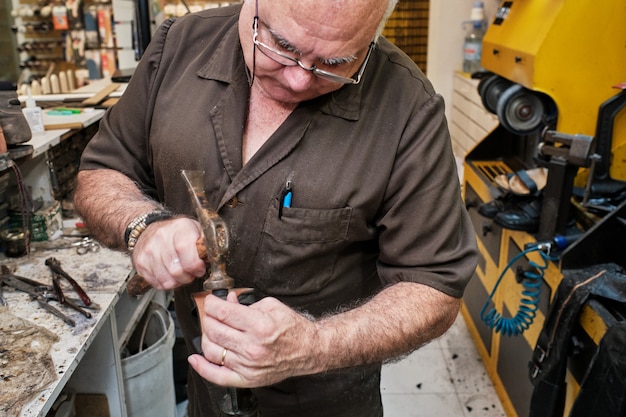 Photo shoemaker man working in his shoe shop