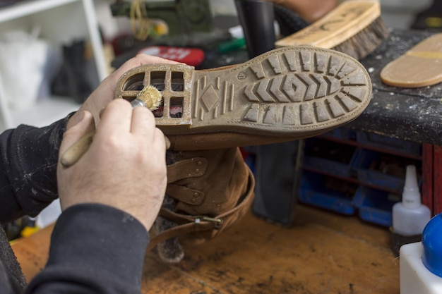 Photo shoemaker performs shoes in the studio craft