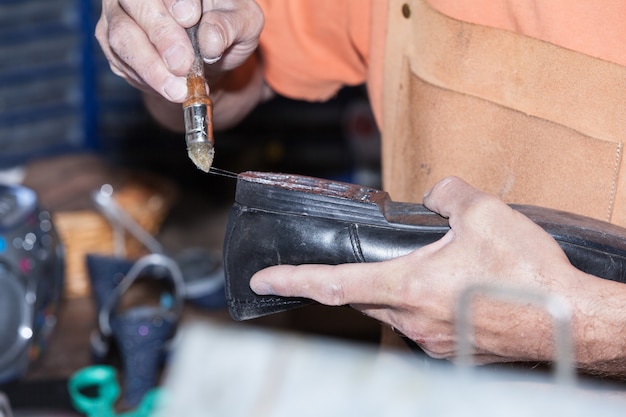 The shoemaker repairs a shoe