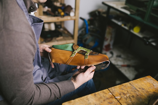 Shoemaker in workshop making leather shoes.