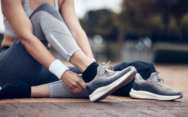 スポーツ女性との靴のフィットネスとエクササイズ、または屋外の歩道でのトレーニングの準備をしているランニング 定期的な実行の準備をしている女性アスリートまたはランナーとの健康と有酸素運動のトレーニング