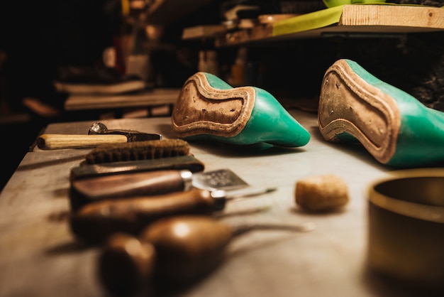 Shoes and instruments on table at footwear workshop.