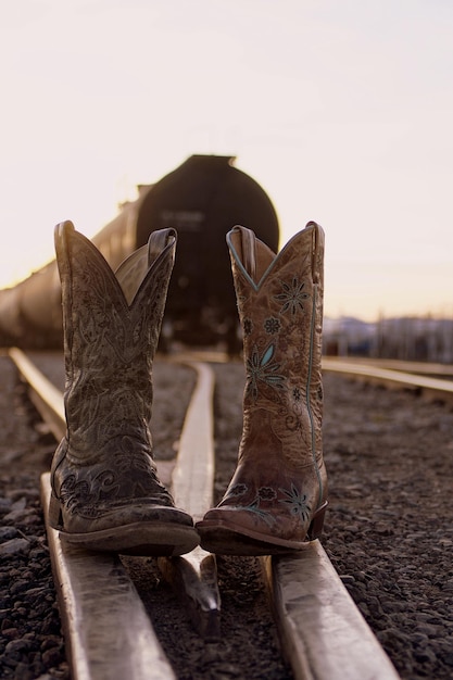 Foto scarpe sui binari ferroviari in un campo