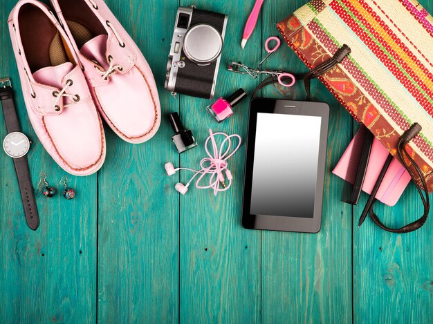신발 태블릿 pc 카메라 가방 메모장 시계 헤드폰 및 파란색 나무 책상에 필수품