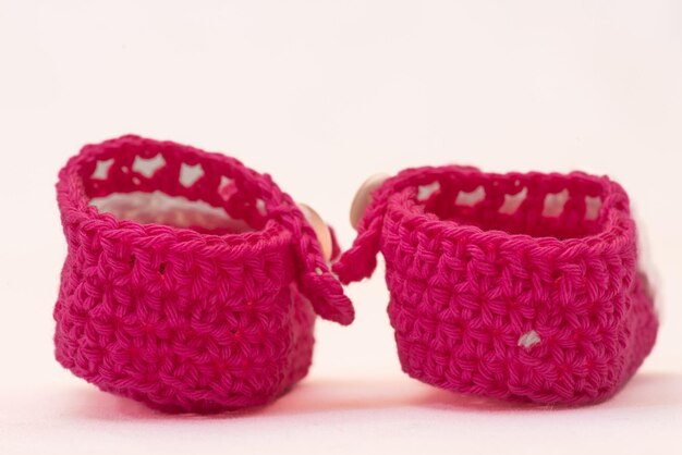 Shoes with faces for a newborn crocheted on a white background