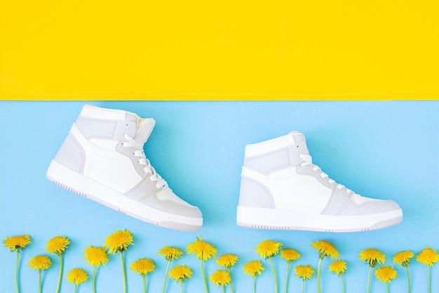 Scarpe e fiori gialli su sfondo blu giallo passo dopo passo in stile piatto concetto creativo di successo e sviluppo vista dall'alto