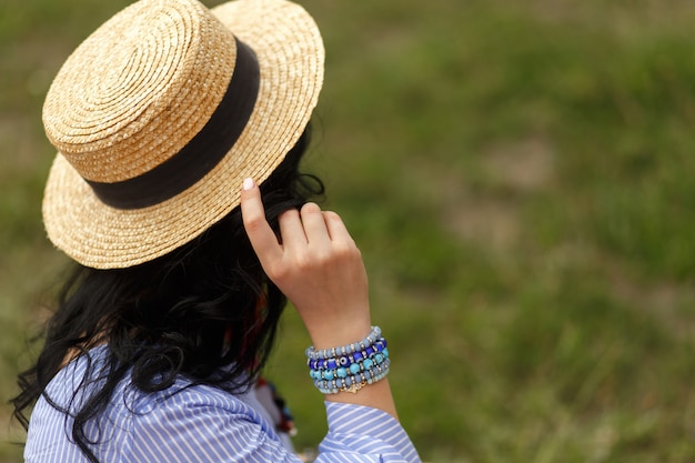 Shoot from back of woman hold her hat.