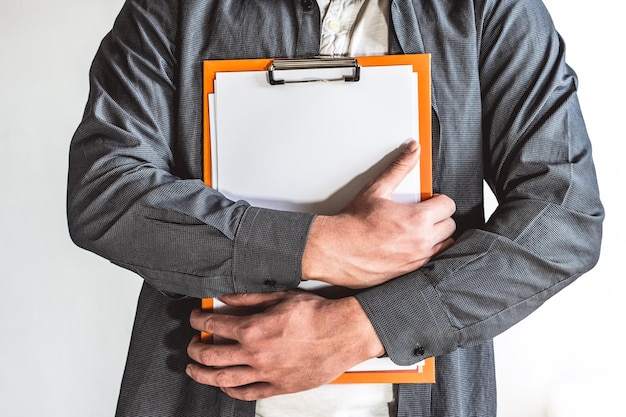 Photo shoot of man with blue shirt who is standing holding folder on a white background