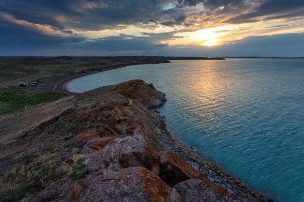 A shoot of a sunset over a lake, with beautiful warm colors and clouds and perfectly symmetryc reflections