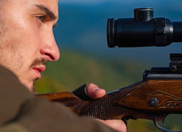 Shooter man hunter sighting in the target close up snipers carbine at the outdoor hunting target wit