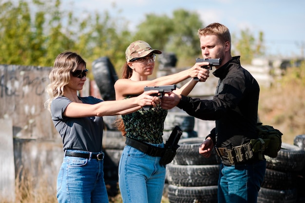 Photo shooting instructor teaching a women how to properly handle a weapon at the shooting range