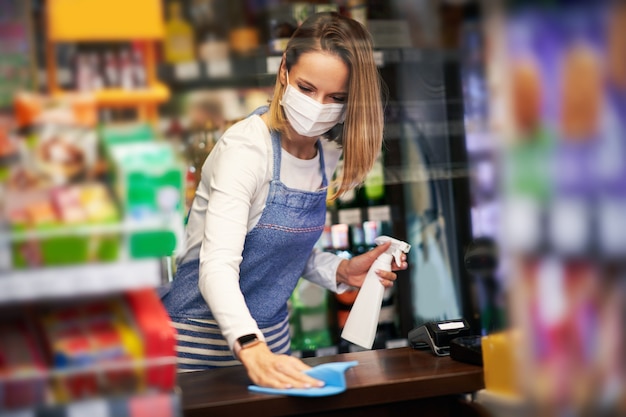 食料品店の表面を消毒する店員