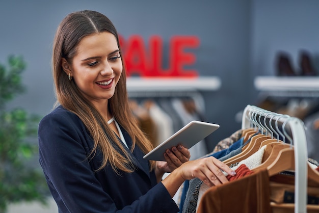 冬の秋のコレクションを持つ彼女のブティックの店員