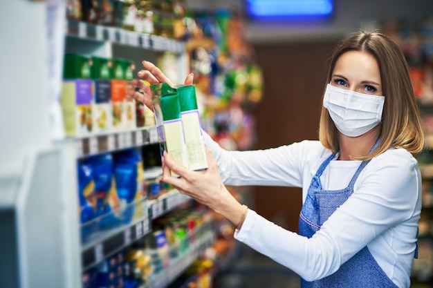 shop assistant working in medical mask in grocery store